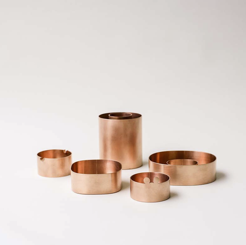 Kim Hyung Sung - Fünf Gefäße aus Kupfer. Zwei davon runde niedrige Aschenbecher, einer mit kleinen runden Ohren als Ablage. Die anderen drei ovale Gefäße, zwei niedrige, ein hohes. Das hohe und ein niedriges als Ring gearbeitet.